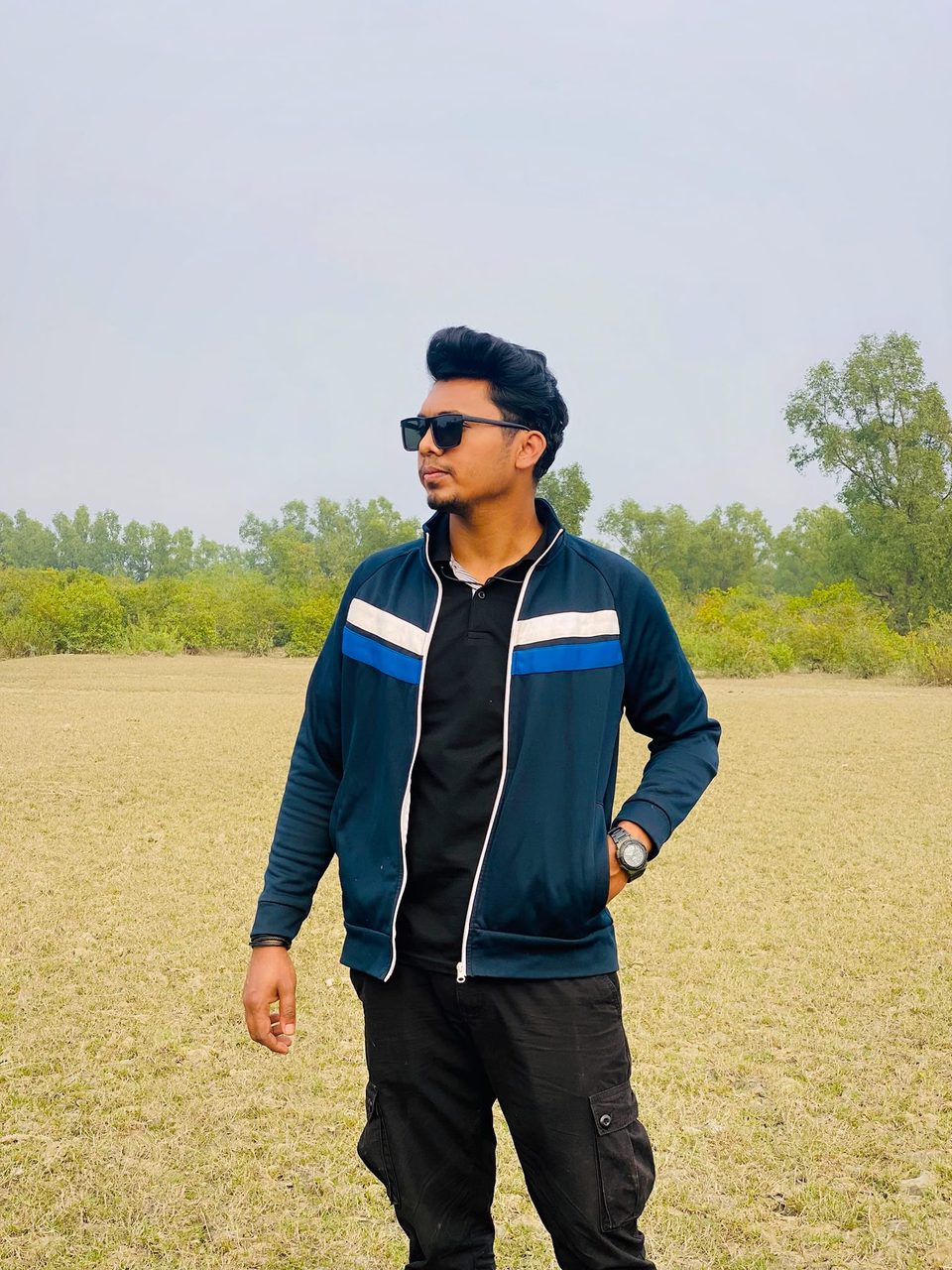 Shahriar in a navy suit near a roadside banner