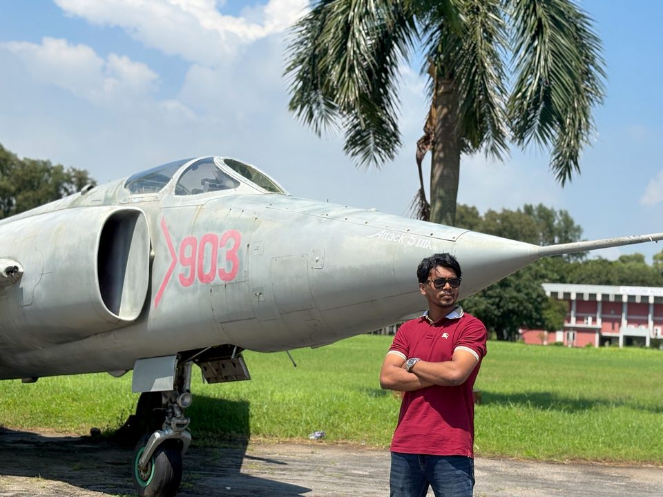 Shahriar standing beside a military aircraft outdoors